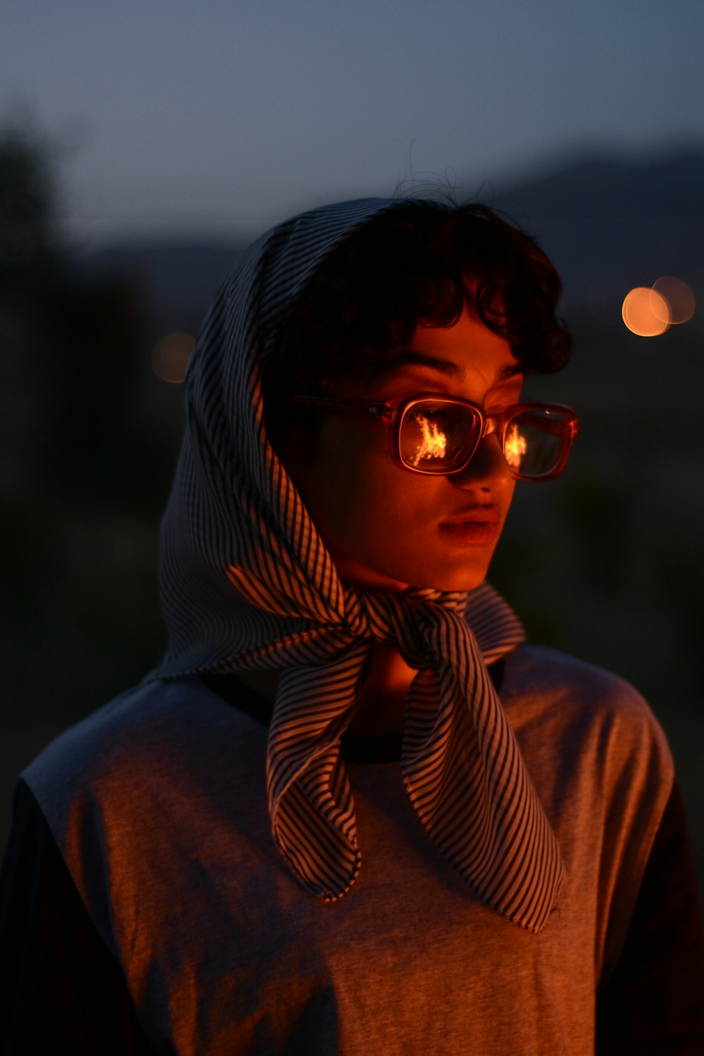 a person wearing a scarf and glasses at night