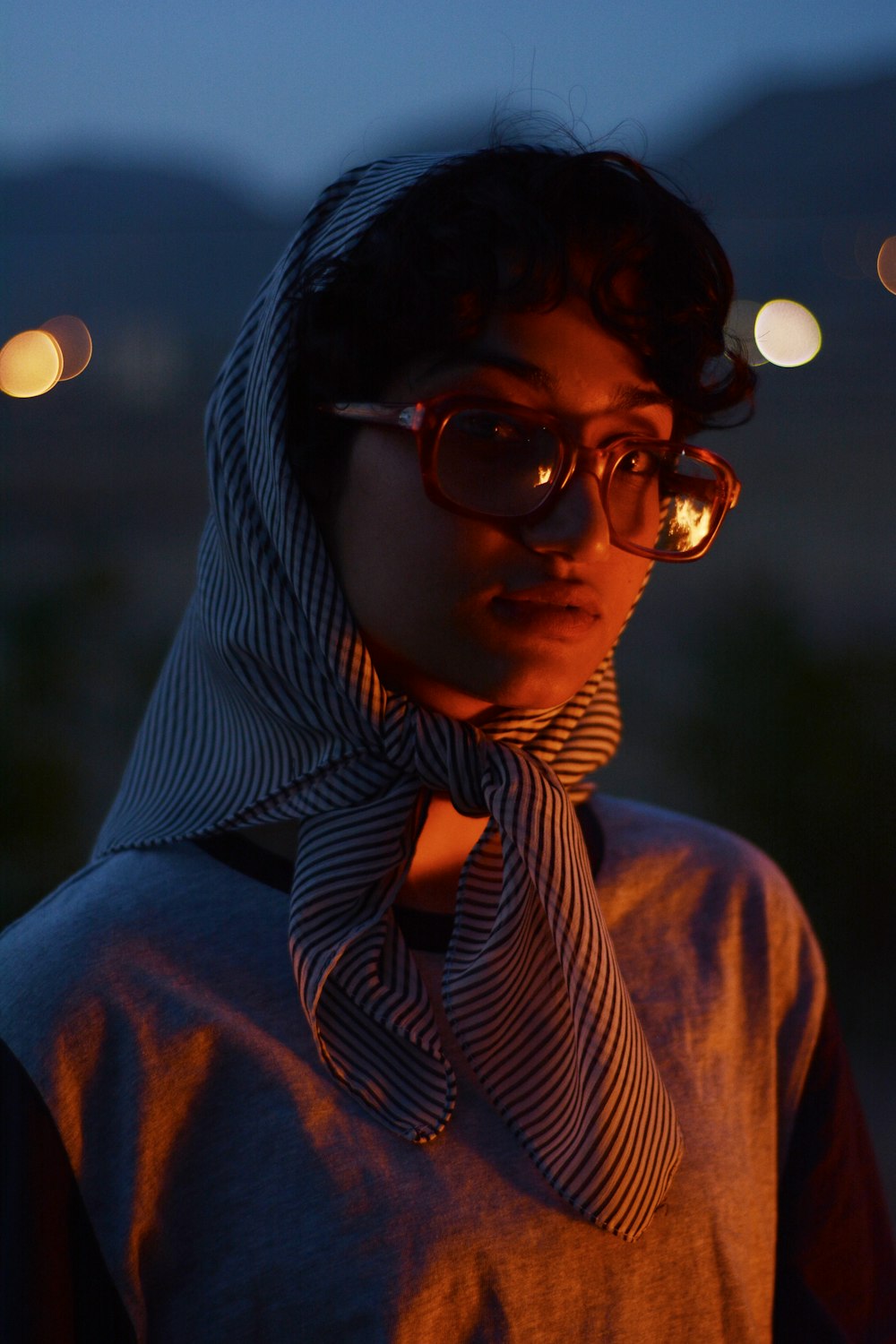 a woman wearing glasses and a scarf around her neck