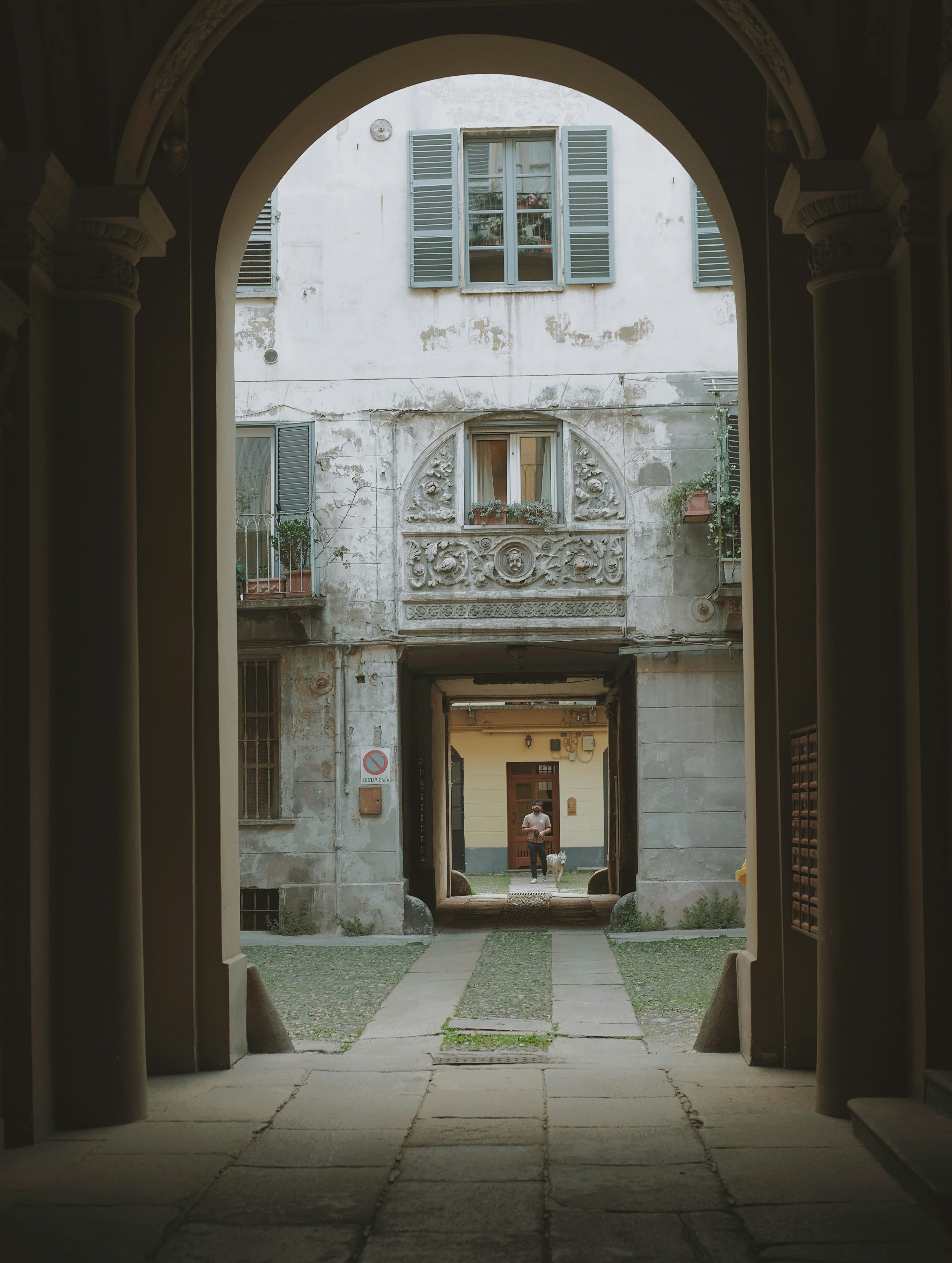 an archway leading into a building with a person standing in the doorway