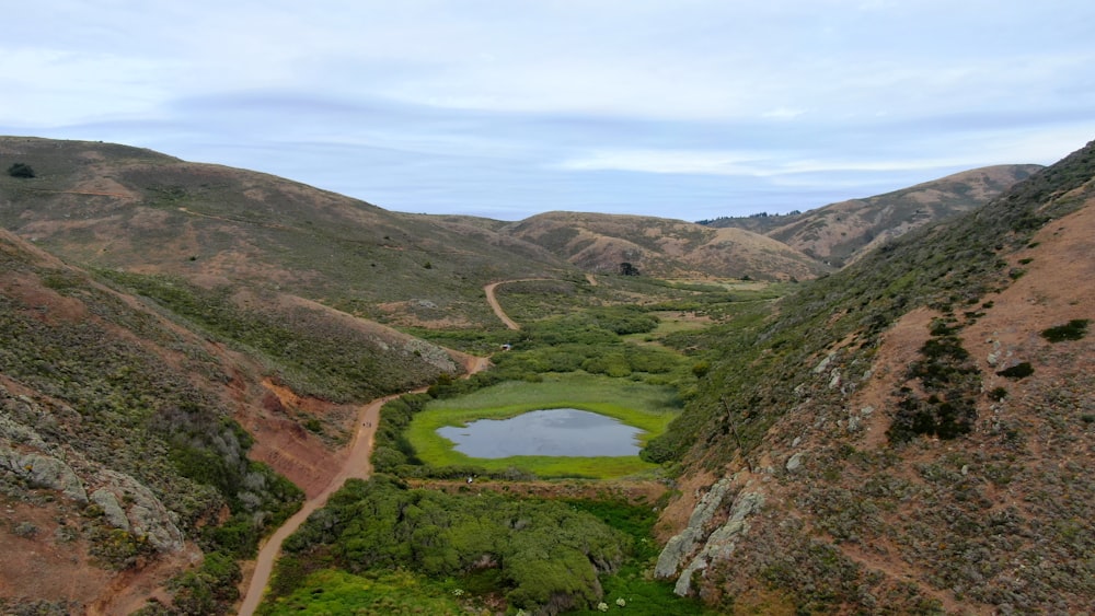 a view of a small lake in the middle of a valley