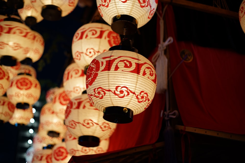 a bunch of red and white lanterns hanging from a ceiling