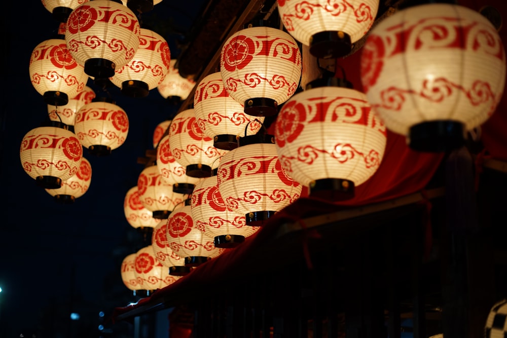 a group of red and white lanterns hanging from a ceiling