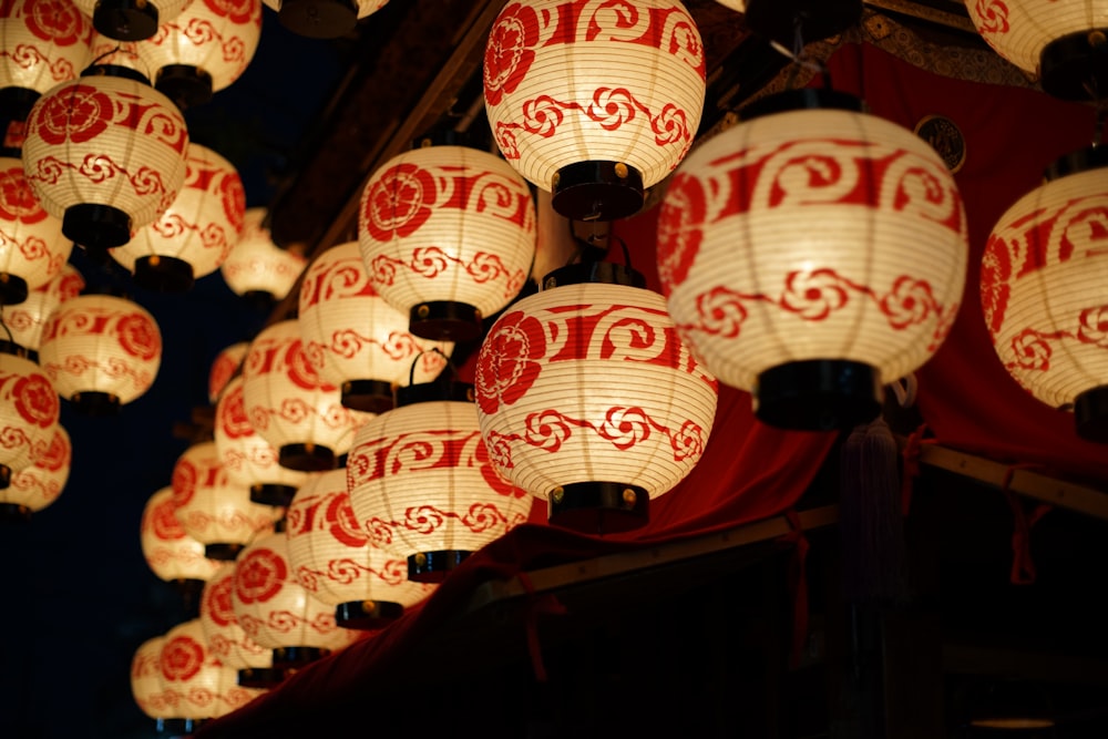 a group of red and white lanterns hanging from a ceiling