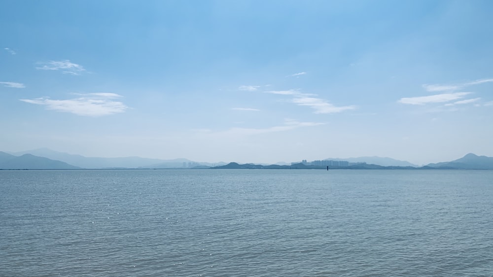 a large body of water with mountains in the background