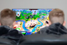 two boys are playing a video game on the television