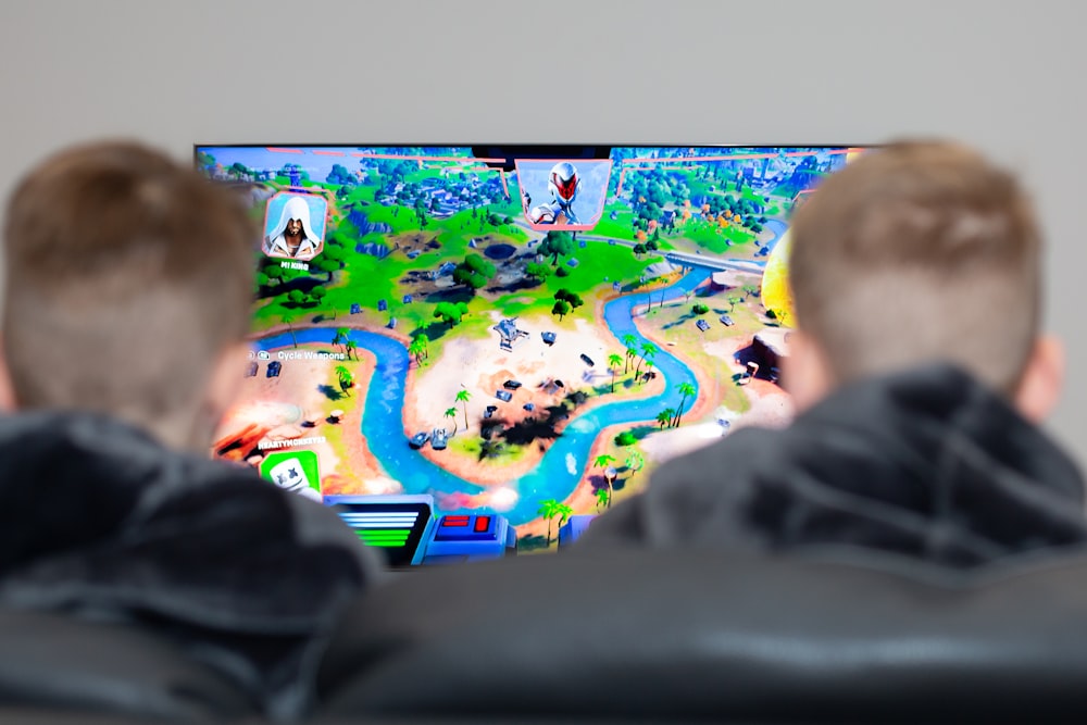 two boys are playing a video game on the television