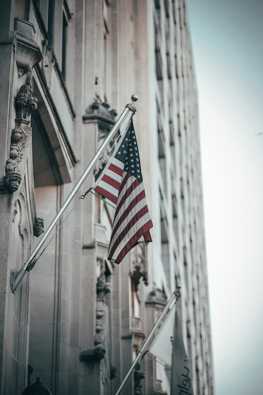 an american flag flying in front of a tall building