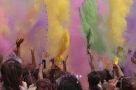 Close-up of hands throwing bright neon color powder into the air