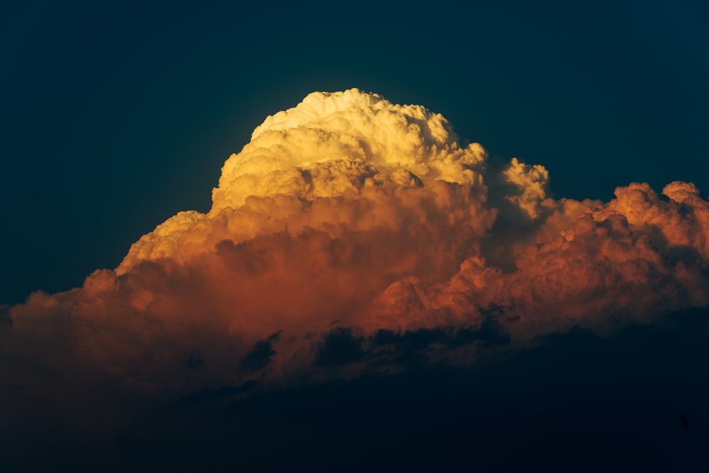 a large cloud in the sky with a bright orange glow