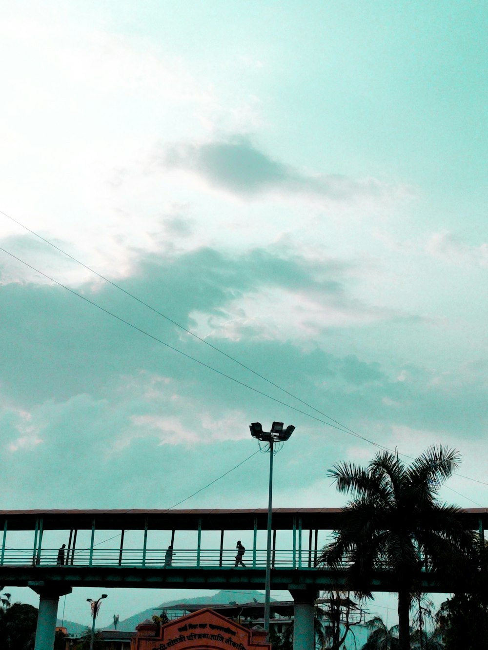 a person walking across a bridge over a street