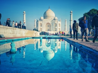 The majestic Taj Mahal at sunrise, reflecting its beauty in the calm waters.