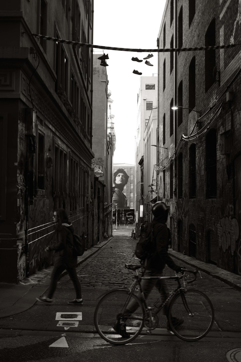 a man riding a bike down a street next to tall buildings