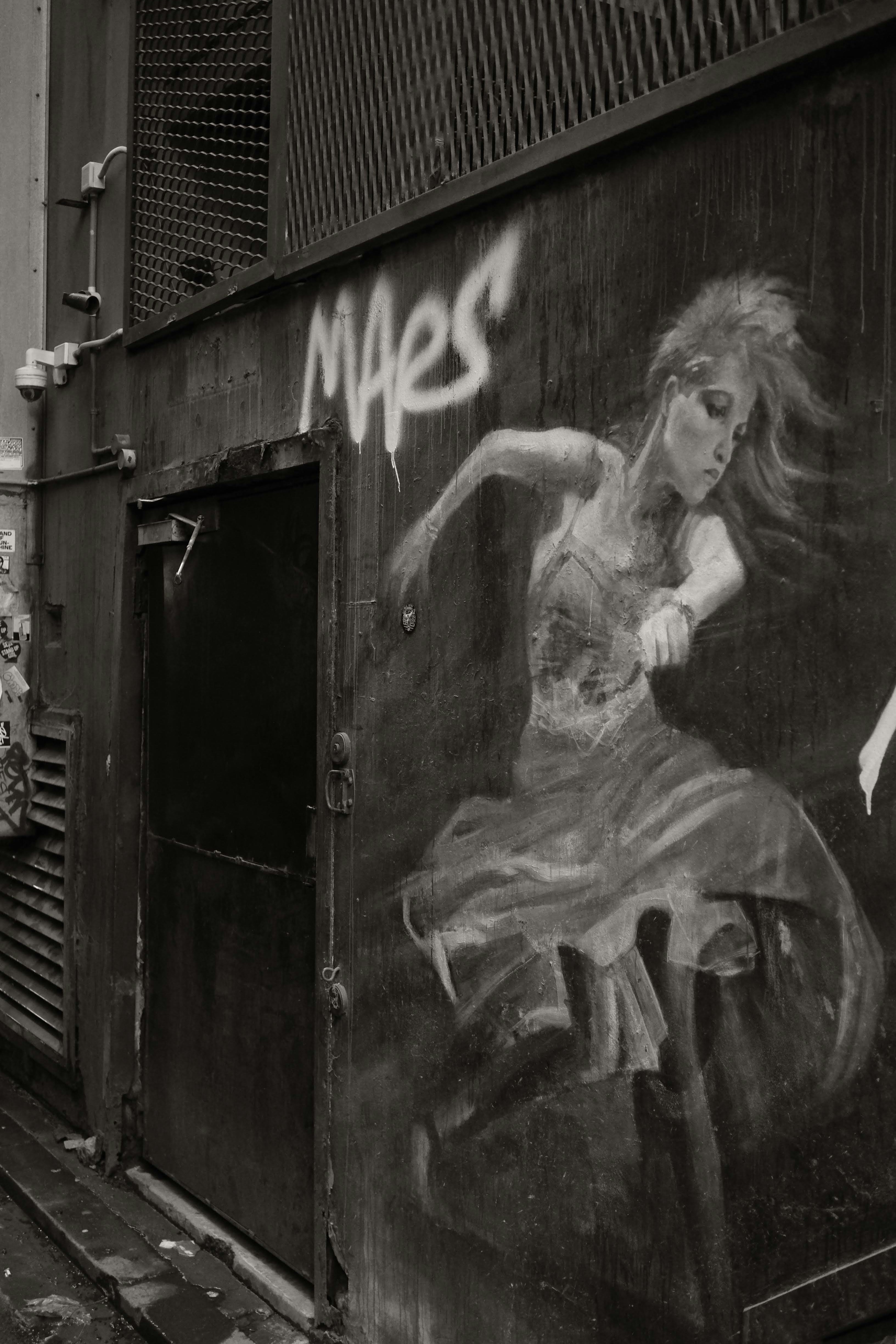 Graffiti painting of a dancer next to an alleyway door