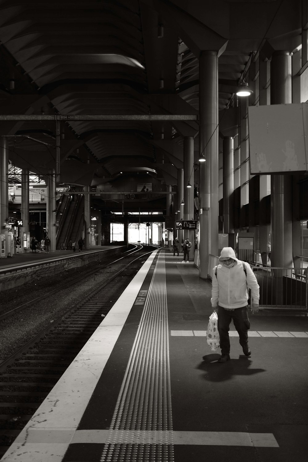 um homem com um saco está esperando em uma estação de trem