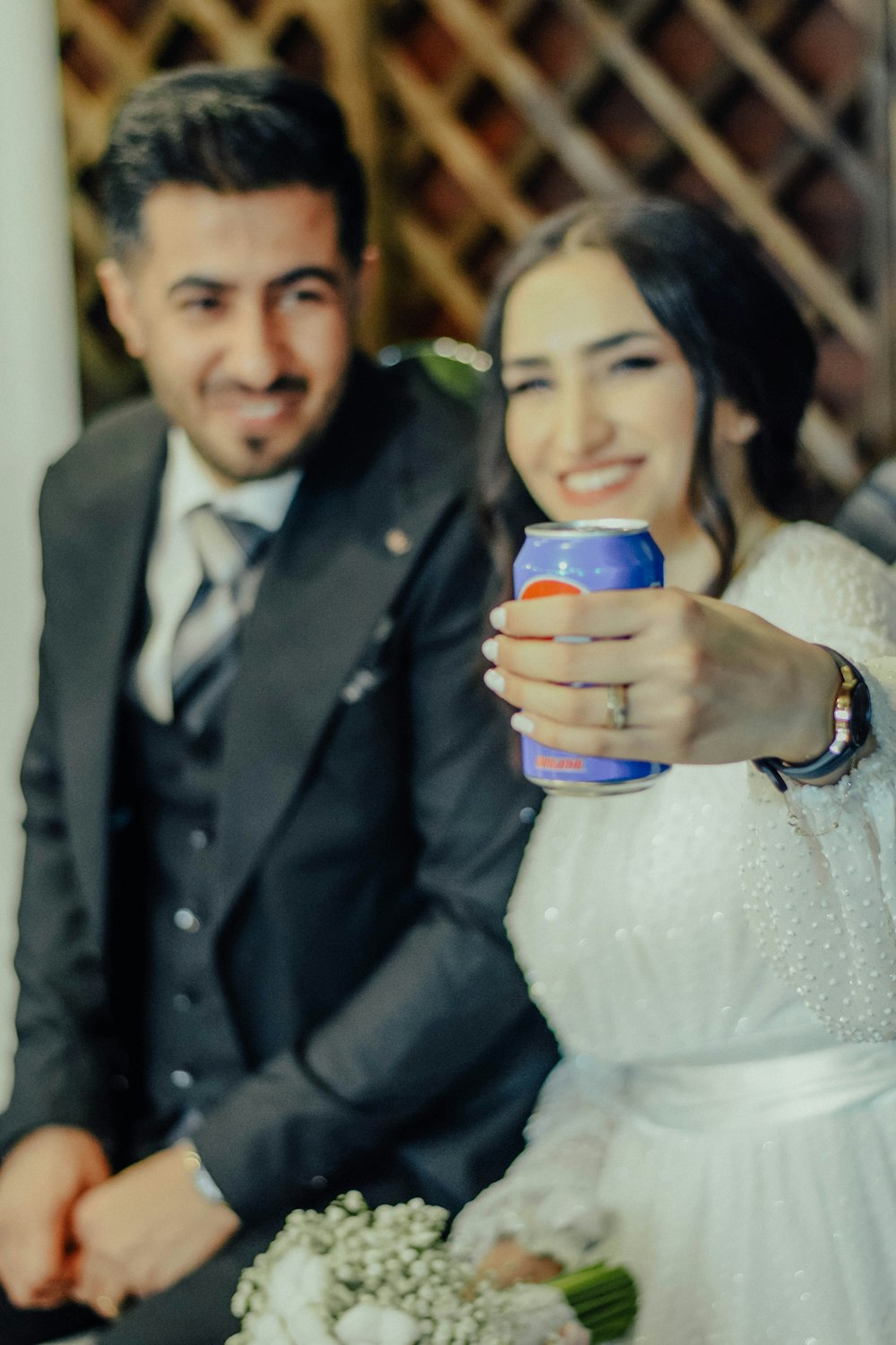 a bride and groom holding a can of beer