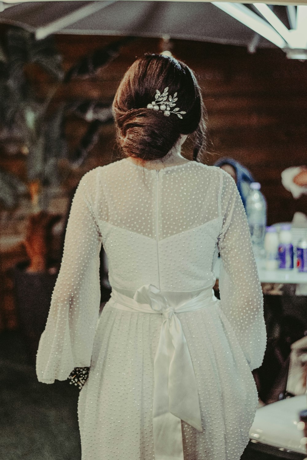 a woman in a white dress is standing in a room