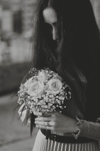 a woman holding a bouquet of flowers in her hands