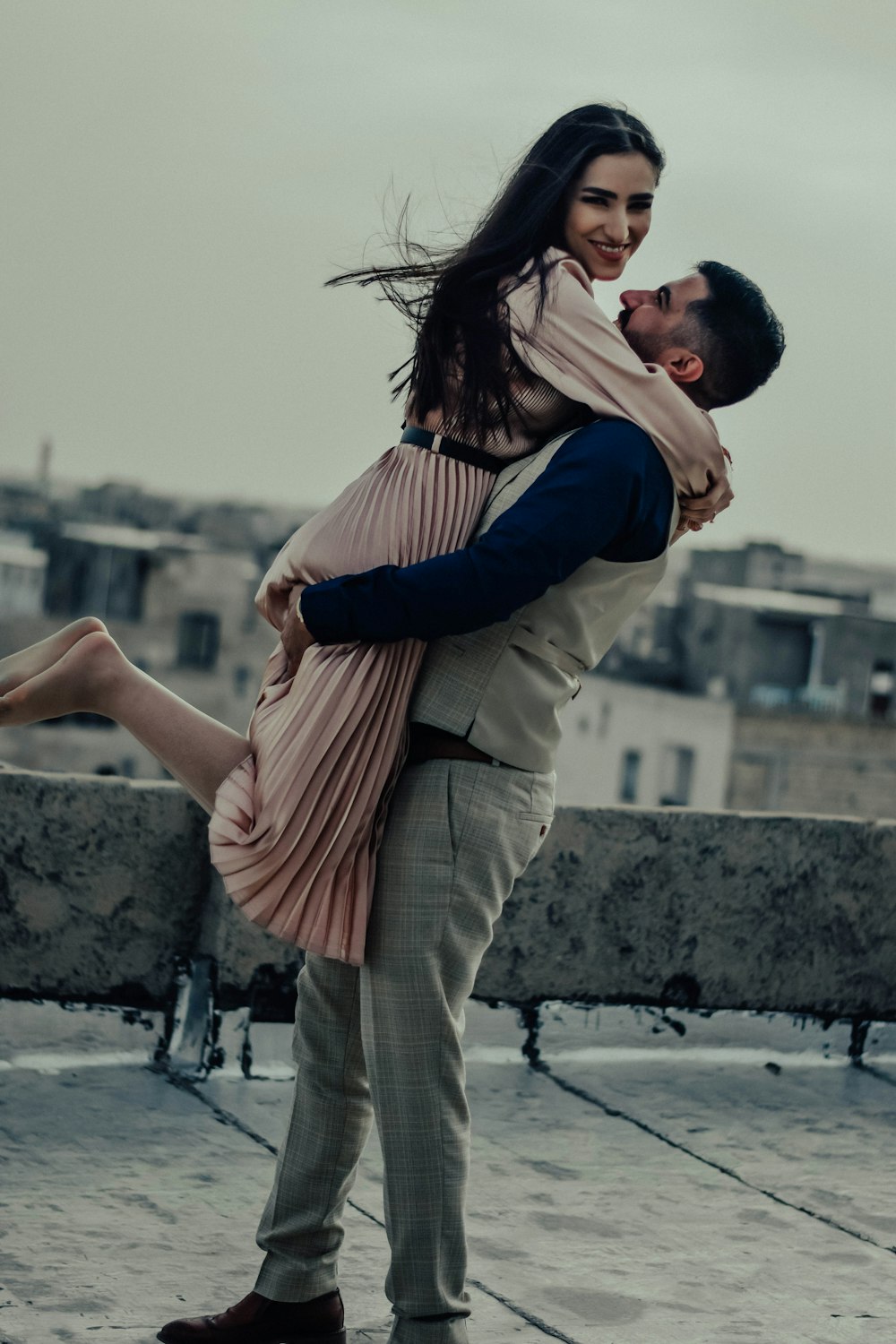 a man holding a woman on top of a roof