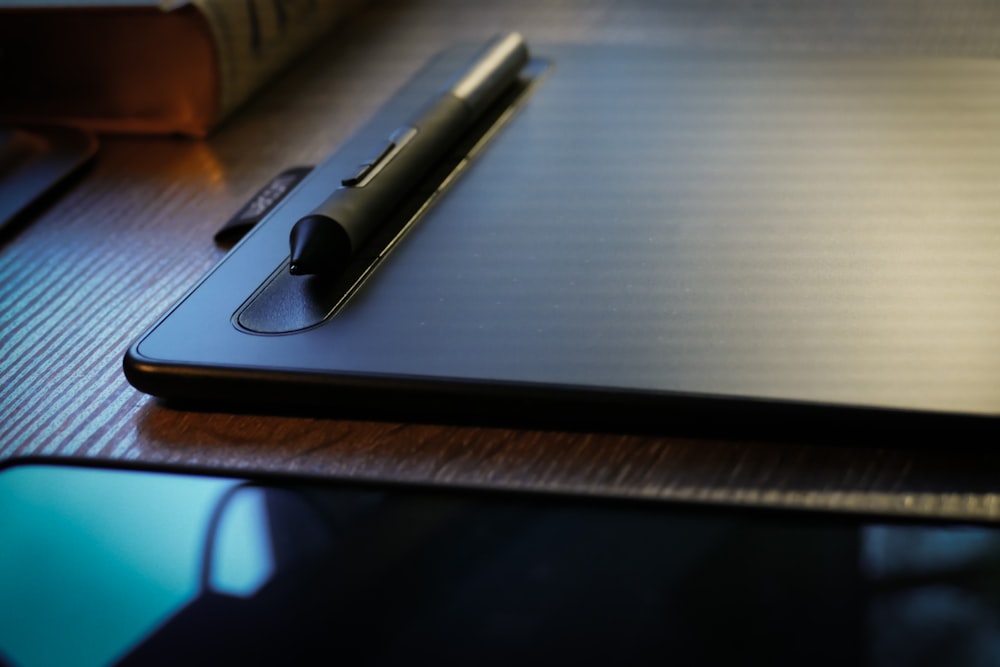 a pen sitting on top of a laptop computer