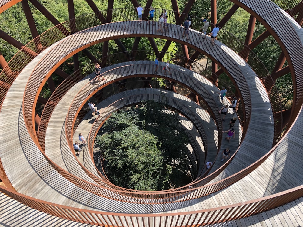 a group of people walking across a wooden bridge