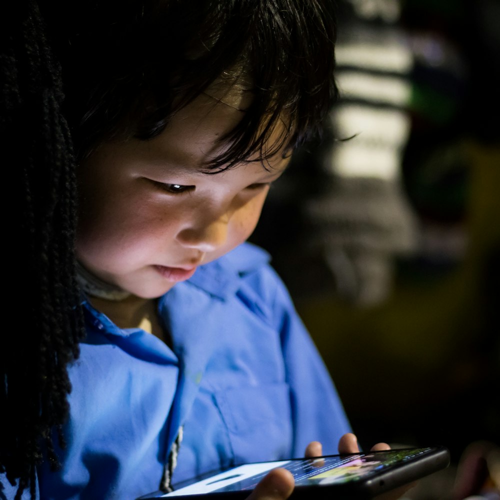 un jeune enfant regarde une tablette