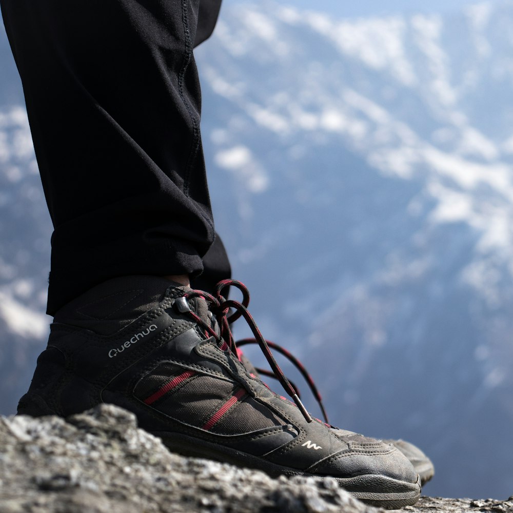 Una persona parada en la cima de una montaña rocosa