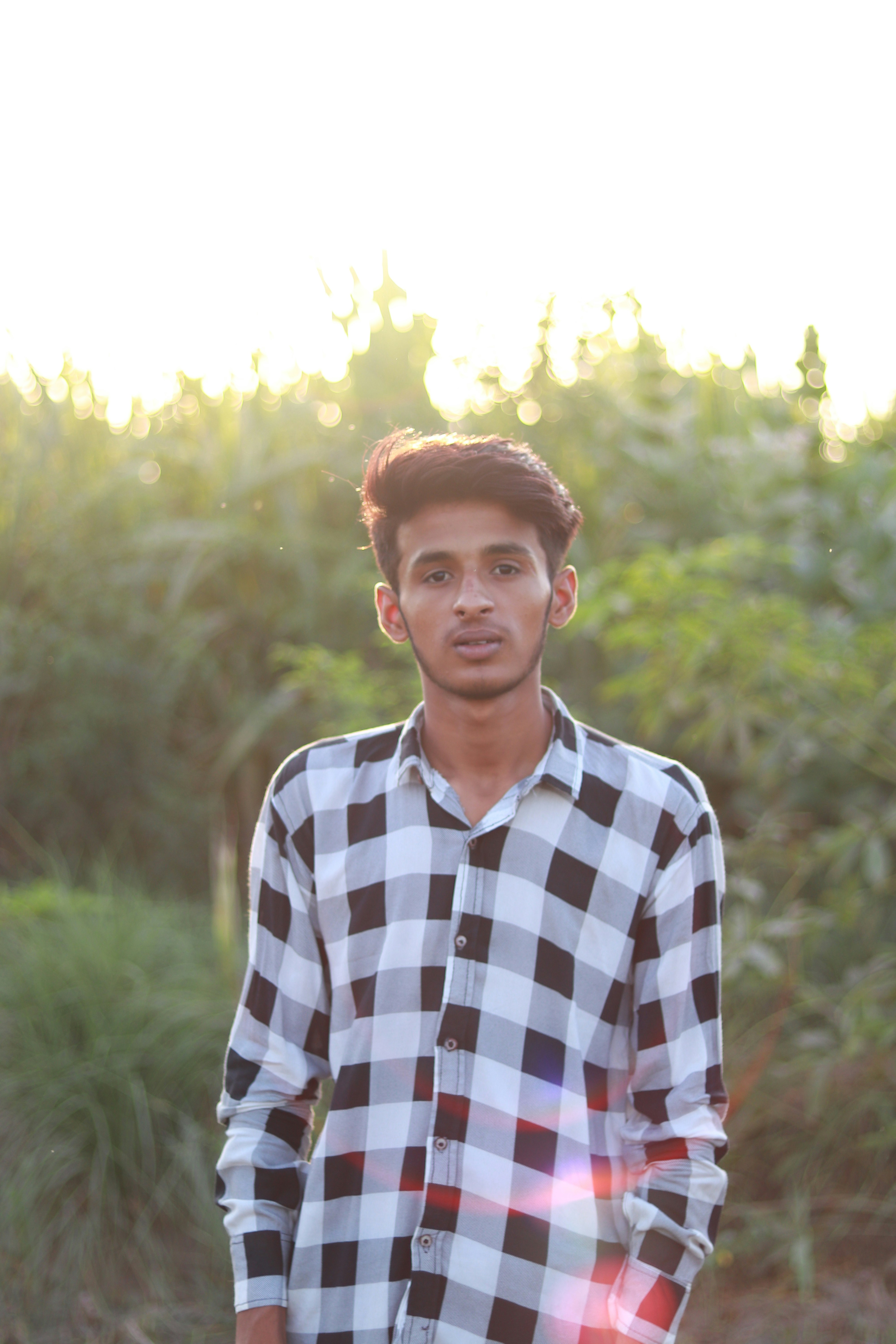 a young man standing in front of a forest