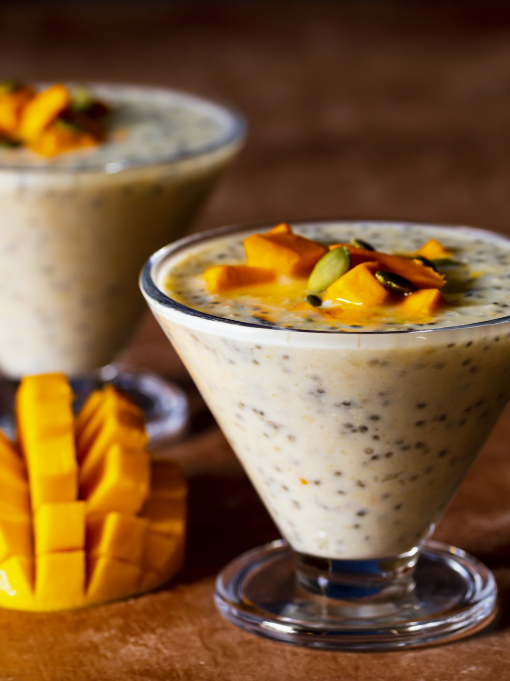 two glasses of fruit and oatmeal on a table