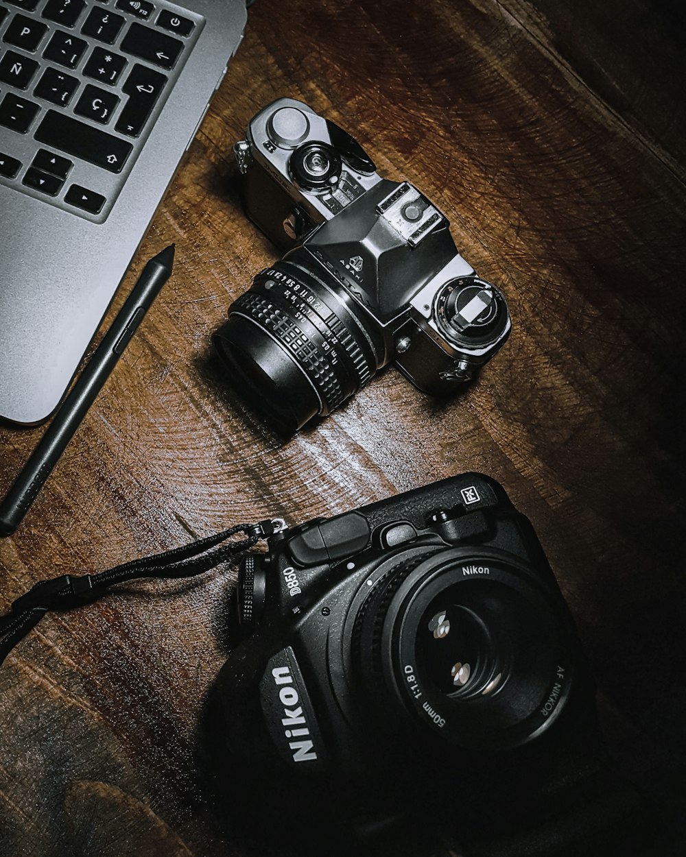 a camera and a laptop on a wooden table