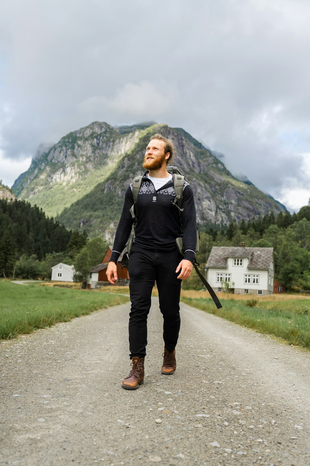 a man walking down a dirt road with a rifle