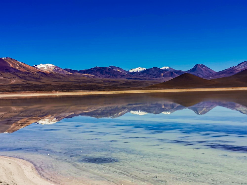 a body of water with mountains in the background