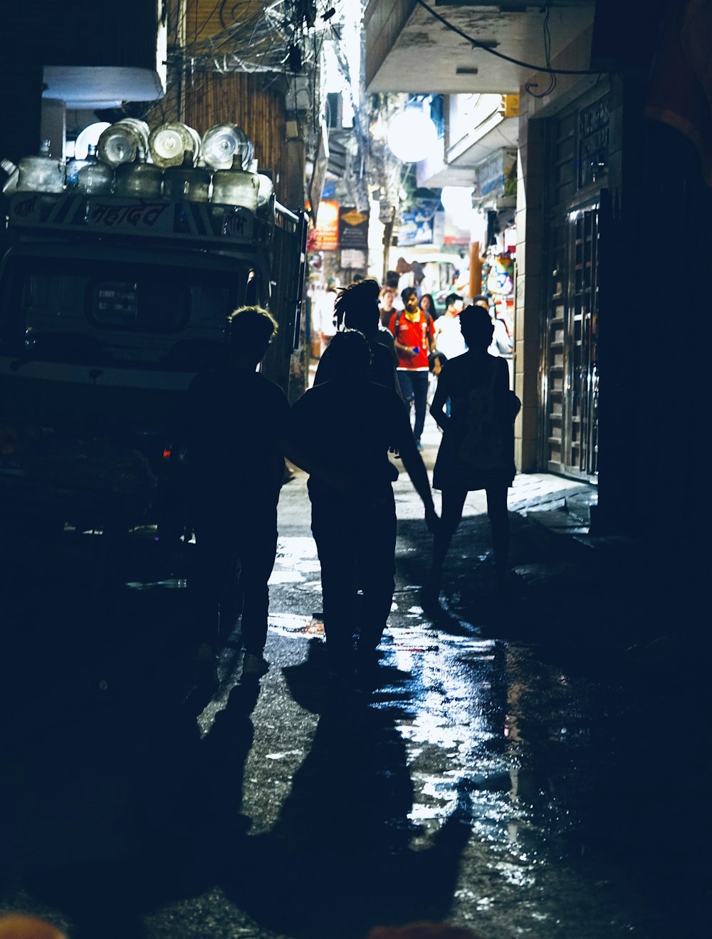 a group of people walking down a street at night