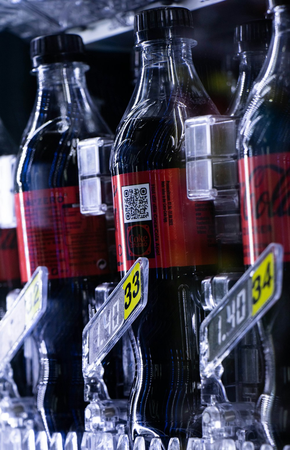 bottles of soda are lined up on a shelf