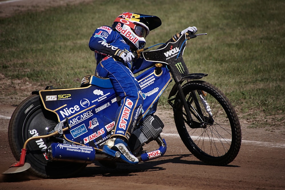 a man riding a motorcycle on top of a dirt road