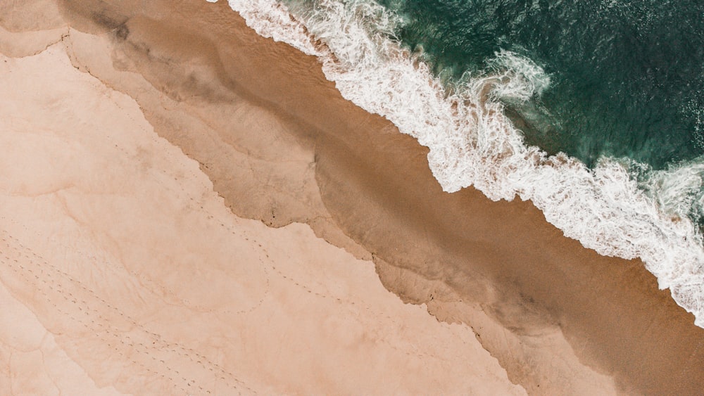 Une vue plongeante sur une plage de sable et l’océan