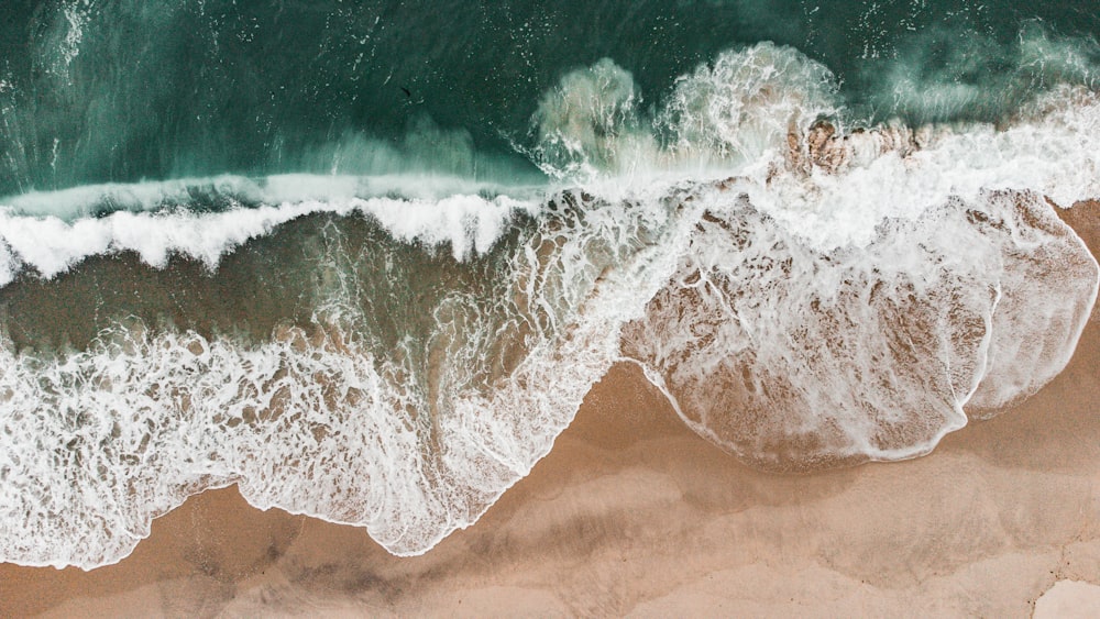 an aerial view of a beach with waves crashing on it