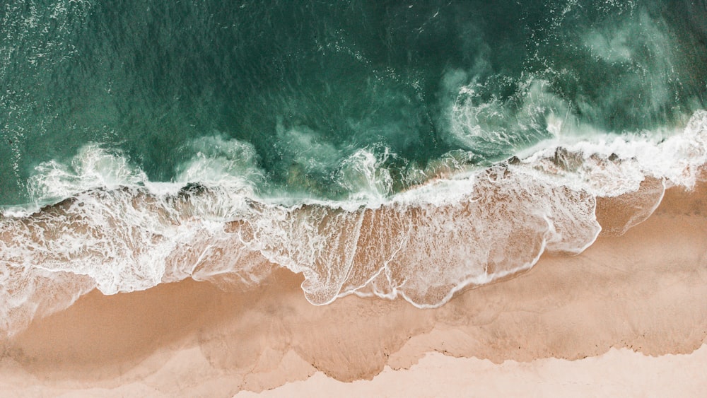 an aerial view of a beach with waves and sand