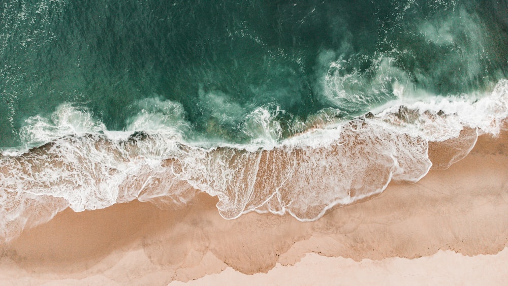 uma vista aérea de uma praia com ondas e areia