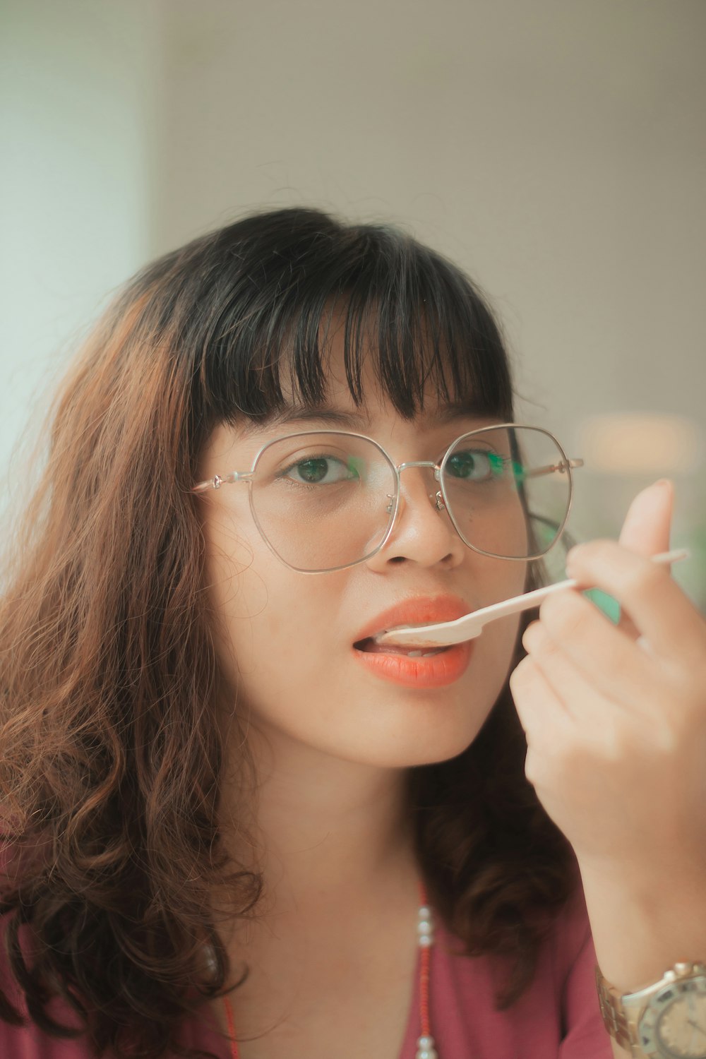 a woman with glasses is brushing her teeth