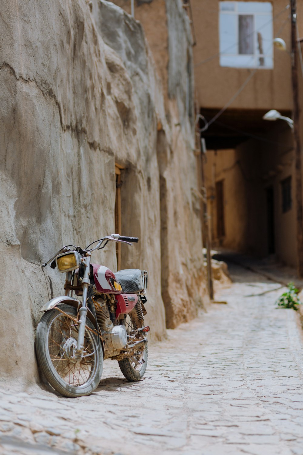 a motorcycle is parked on a cobblestone street