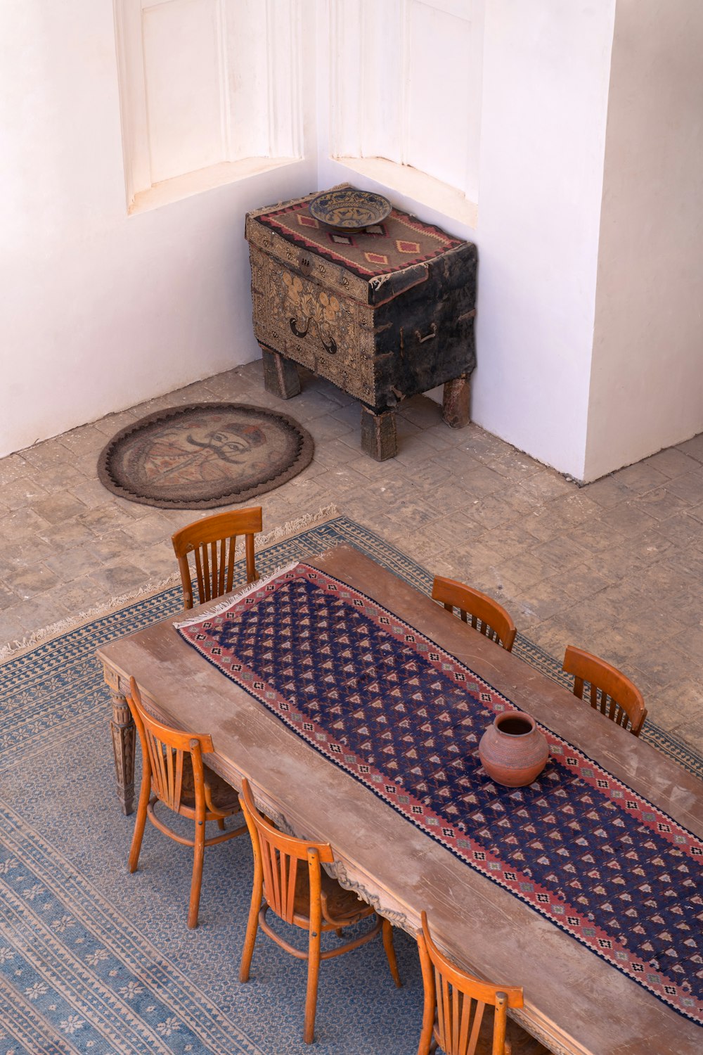 a room with a table and chairs and a rug on the floor