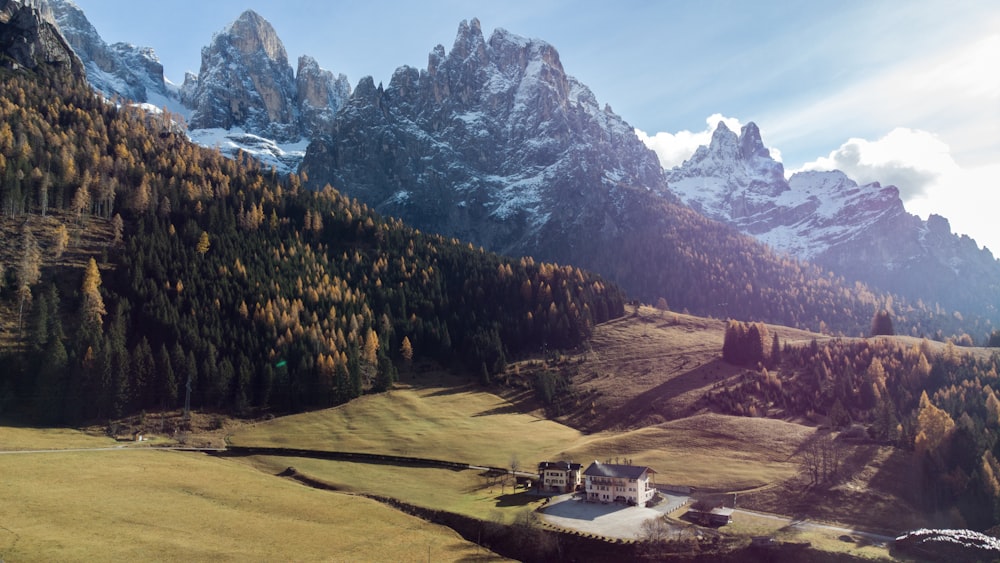 a scenic view of a mountain range with a house in the foreground