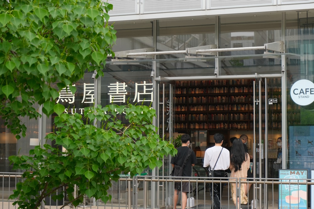 a group of people standing outside of a cafe