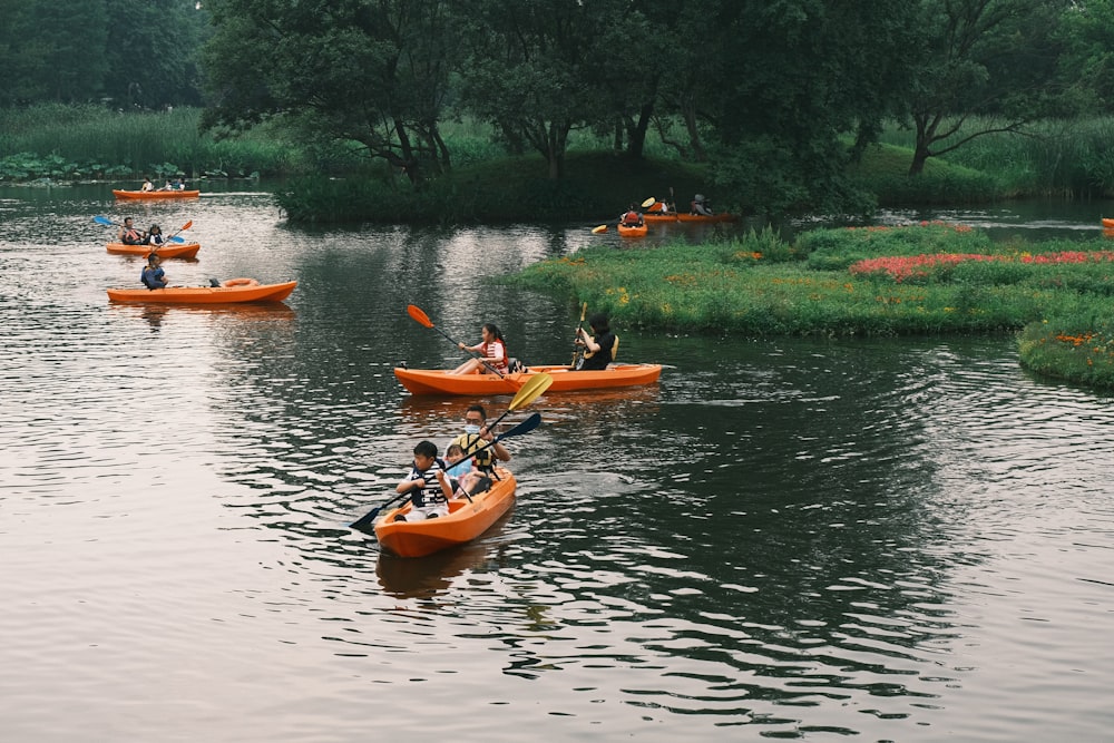 a group of people in canoes paddling down a river