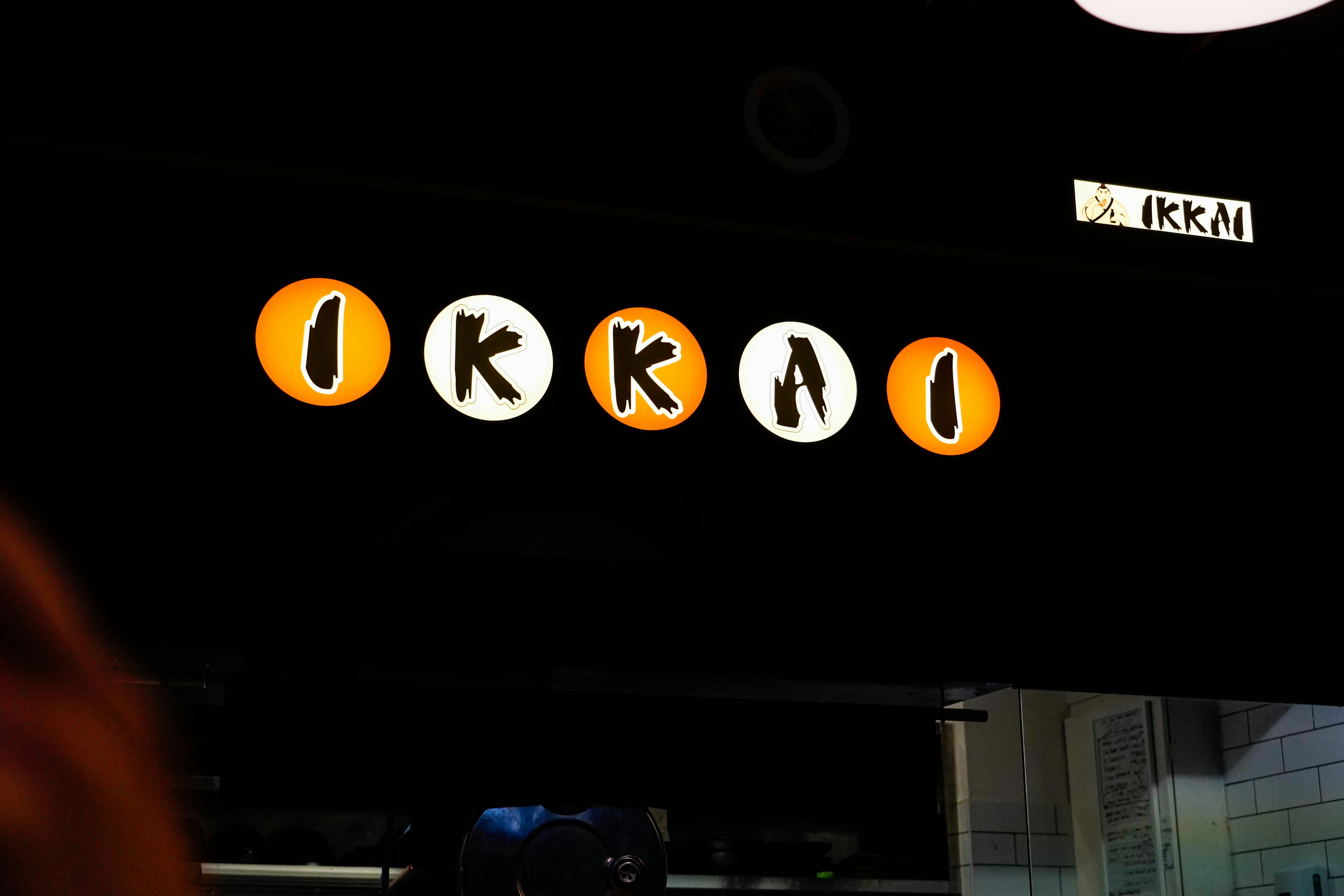 a person standing in front of a sign for a restaurant