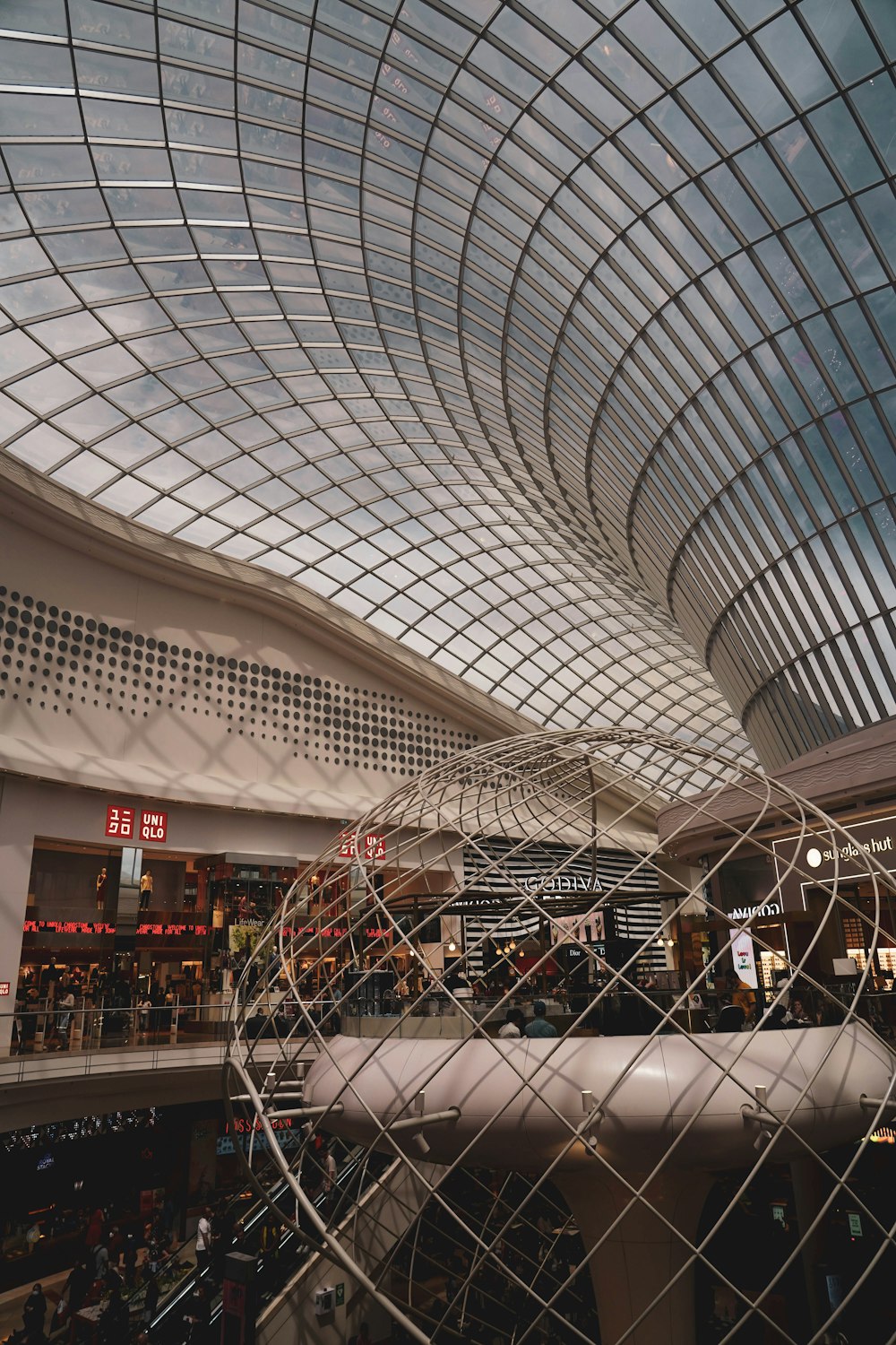 a view of a shopping mall through a chain link fence