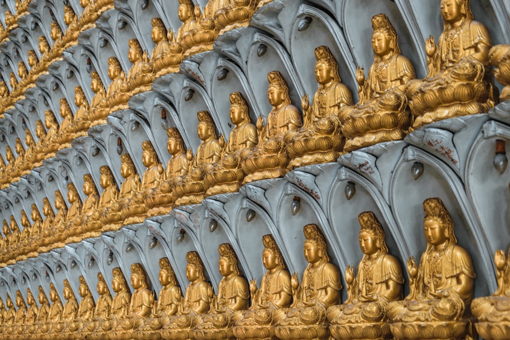 a large group of golden buddha statues sitting next to each other