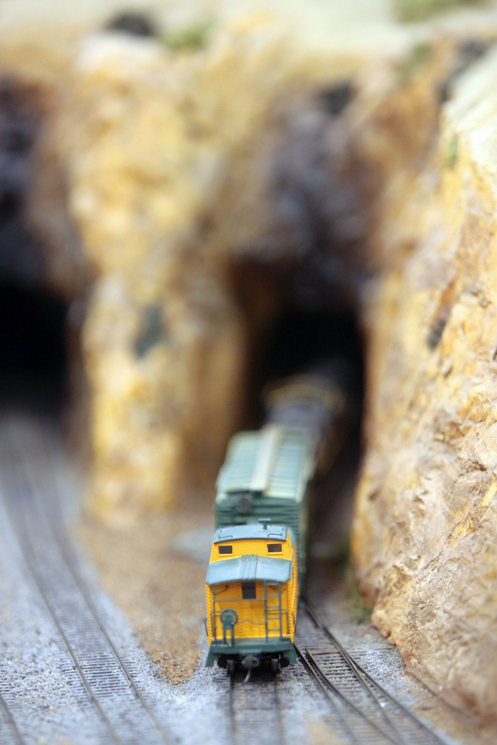um trem de brinquedo está saindo de um túnel