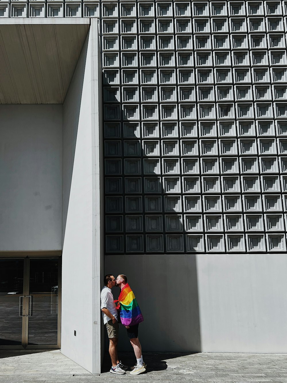 a couple of men standing next to each other in front of a building