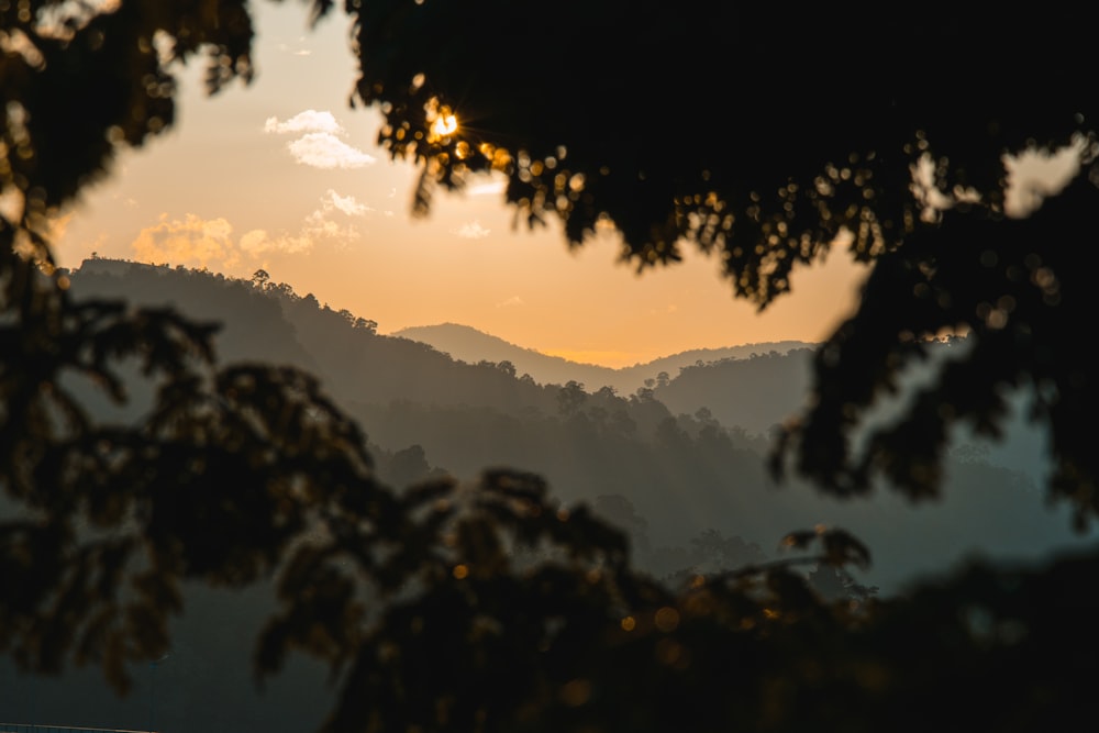 the sun is setting over a mountain range